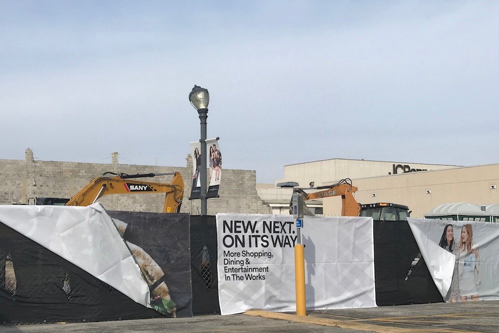 Signage at the construction site teases new development.